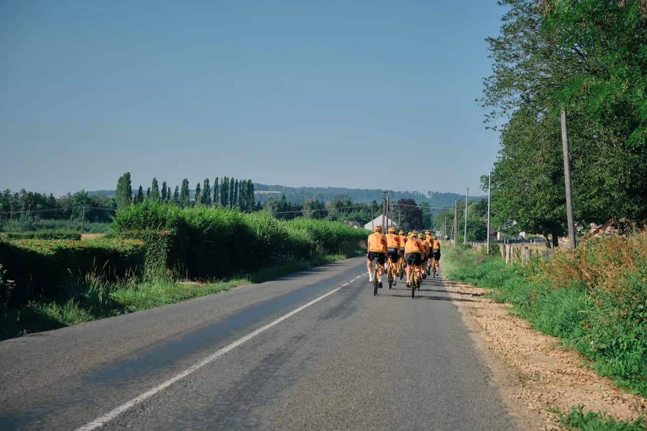 A group of Team Rynkeby riders on an open French country road