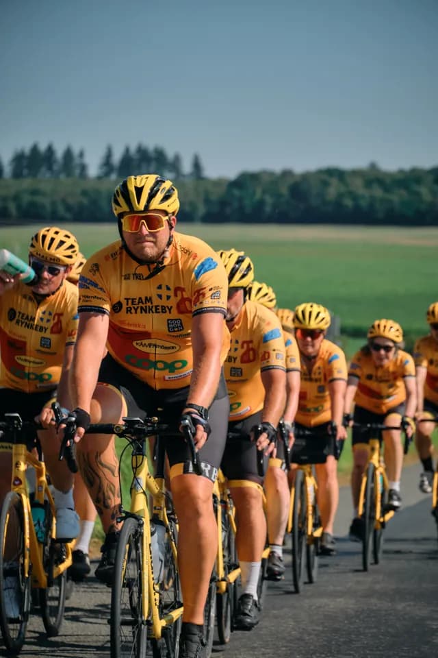 A Team Rynkeby rider leading the group, jersey full of sponsor logos